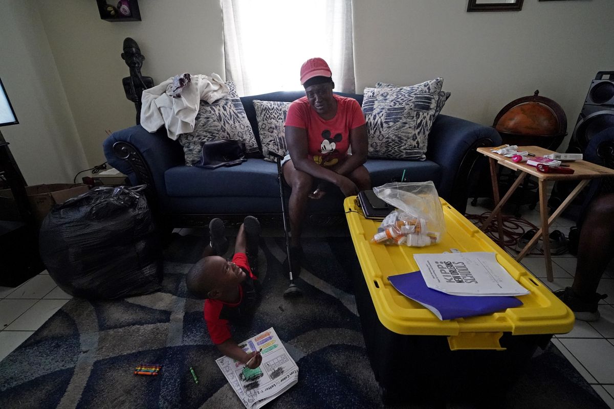 Natasha Blunt sits in her apartment with her grandson Kamille Blunt, 5, Monday in the aftermath of Hurricane Ida in Chalmette, La. Before the hurricane hit, the New Orleans native had hardly recovered from facing eviction and loss of her catering job during the pandemic. The storm, which left her in the dark and without power for several days, has taken Blunt to the brink. Unable to work as her health deteriorates from a pair of strokes, Blunt is still facing eviction while she cares for Kamille.  (Gerald Herbert)