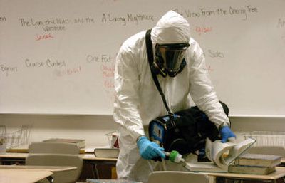 
An EPA contractor uses a sensor device Thursday to detect vapors produced by mercury at Lake City High School. Several plastic capsules containing a dental mercury compound were brought to the school by a student on Monday, prompting a shutdown of the campus Thursday and today for cleanup. 
 (Jesse Tinsley / The Spokesman-Review)