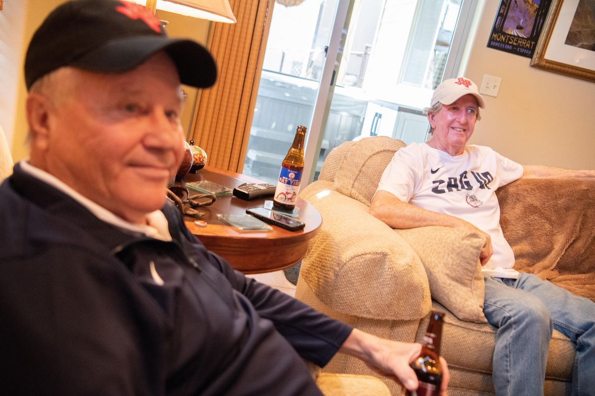 David Hicks, left, and Doug Heiskell sit in Heiskell’s basement in Spokane and watch the start of the NCAA Tournament Elite Eight game between Texas Tech and Gonzaga on Saturday.  Both are 1972 grads of Texas Tech but also Gonzaga fans. (Jesse Tinsley / The Spokesman-Review)