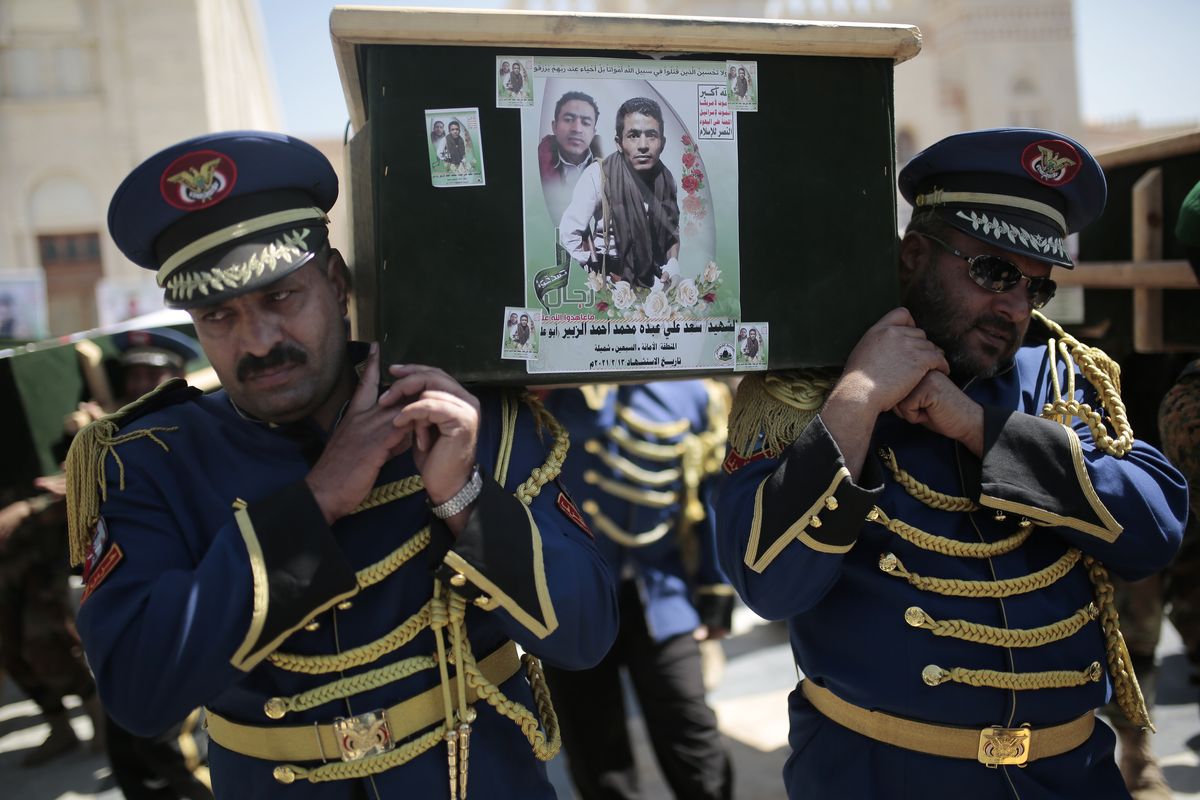 FILE - In this Feb. 16, 2021 file photo, honor guards carry coffins adorned with photographs of Houthi rebel fighters who who were killed in recent fighting with forces of Yemen