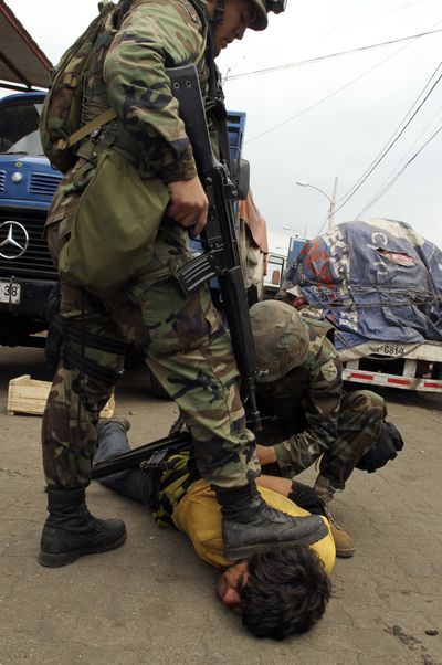 Soldiers arrest a looter at a market in Hualpen, near Concepcion, Chile, on Tuesday. Troops enforce a curfew in this earthquake-stricken coastal region.  (Associated Press)