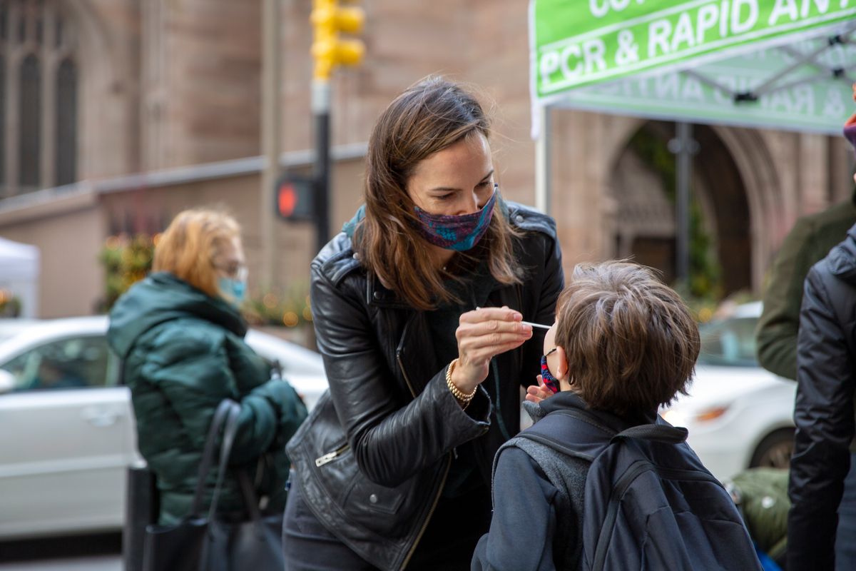 Katie Lucey administers a COVID-19 test on her son Maguire on Thursday at a PCR and Rapid Antigen COVID-19 coronavirus test pop-up site in New York. (Ted Shaffrey)