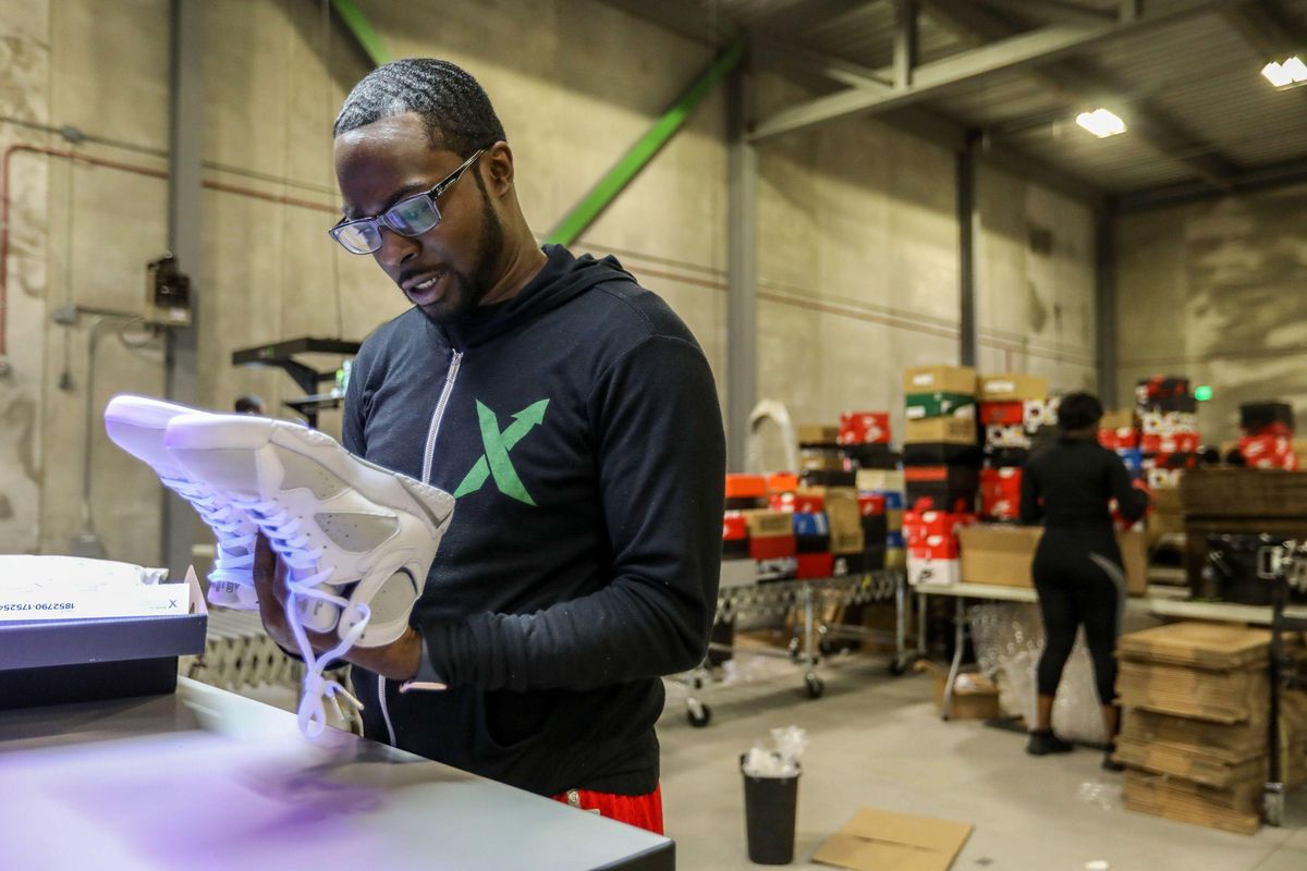 Antonio Gray, 29, of Detroit, worked as a sneaker salesman for six years before becoming an authenticator at StockX, where he looks over a pair of Air Jordans at the company’s new authentication center in Detroit on Tuesday, July 3, 2018. (Tribune News Service)