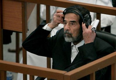 
Former Iraqi President Saddam Hussein adjusts his headset as he listens to a witness Tuesday. 
 (Associated Press / The Spokesman-Review)