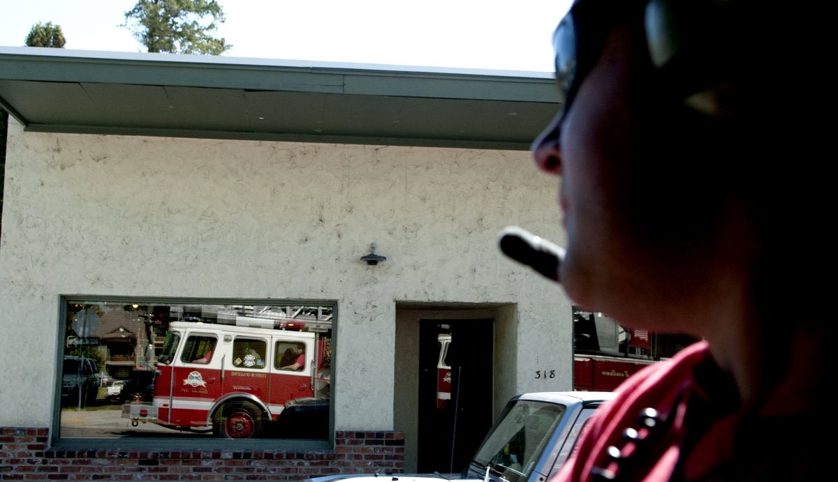 A ladder truck is reflected onto windows of buildings as firefighter Nate Hyder rides to a call Wednesday. The city of Coeur d’Alene has a 10-year bond proposal on the ballot Tuesday to replace its ladder truck, older firetrucks and other equipment. (Kathy Plonka)