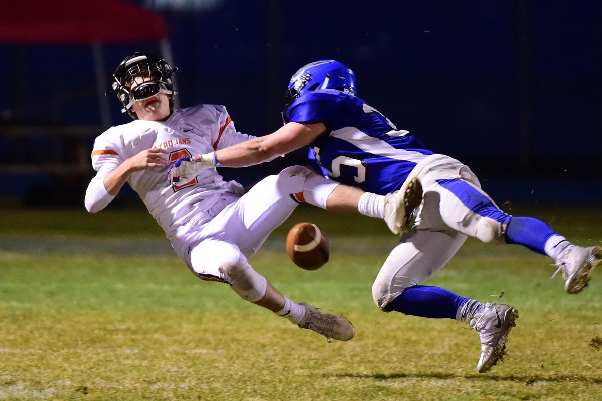 Post Falls quarterback Nate Buer, left, is sacked and the ball comes loose as Coeur d