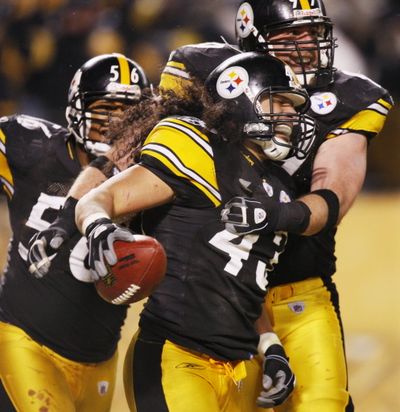 Pittsburgh Steelers safety Troy Polamalu, center, is congratulated by teammates LaMarr Woodley (56) and Brett Keisel after scoring a touchdown after intercepting a pass from Baltimore Ravens quarterback Joe Flacco during the fourth quarter of the NFL AFC championship football game in Pittsburgh tonight. (The Associated Press)