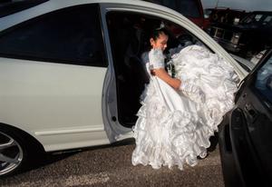 After her quinceanera ceremony in a Pasco church, Ana Chacon, 15, tries to gather up her dress before heading to her party at the local Masonic temple. There, making her first tentative steps to adulthood, she was allowed to dance with boys for the first time. (Colin Mulvany/The Spokesman-Review )