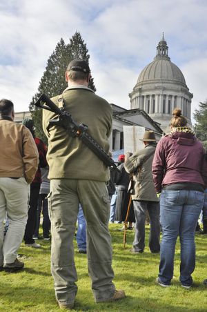 OLYMPIA -- Fred Sittmann of Stanwood, Wash., listens to speakers at a gun rights rally near the state Capitol on Feb. 8. Sittmann brought his 9 mm carbine to the rally, which is legal under the state's open carry law. (Jim Camden)