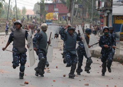 
Policemen flee as they are chased by stone-throwing opposition party supporters in Katmandu, Nepal, on Sunday. 
 (Associated Press / The Spokesman-Review)