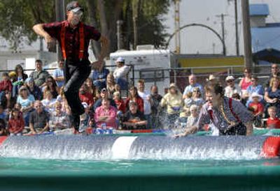 
Les Kinley tries to maintain his balance on a floating log as Chrissy Ramsey falls into the water Sunday during the fair's International Lumberjack Show. 
 (Photos by Holly Pickett / The Spokesman-Review)