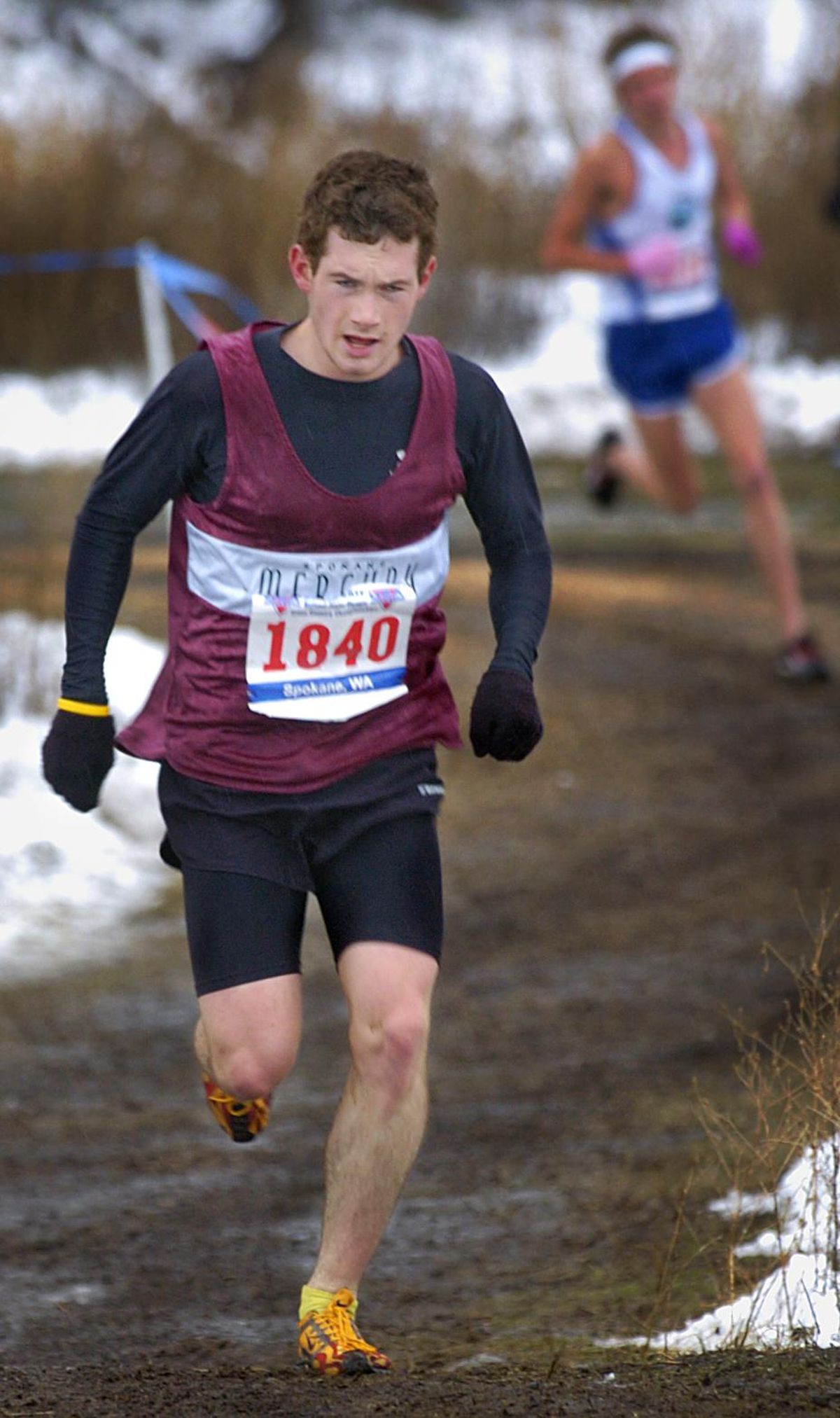 Spokane Mercury cross country team competitor, Greg Billington, climbs a muddy hill a mile from the finish of the young men