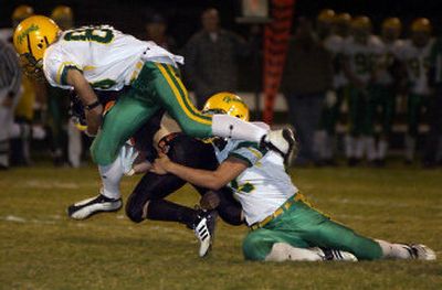 
Lakeland's Ian Kelsey, left, and Josh Wuest bring down Trojans fullback and homecoming king Bobby Kuber at Post Falls High School. The Trojans won the Inland Empire League game.
 (Tom Davenport / / The Spokesman-Review)