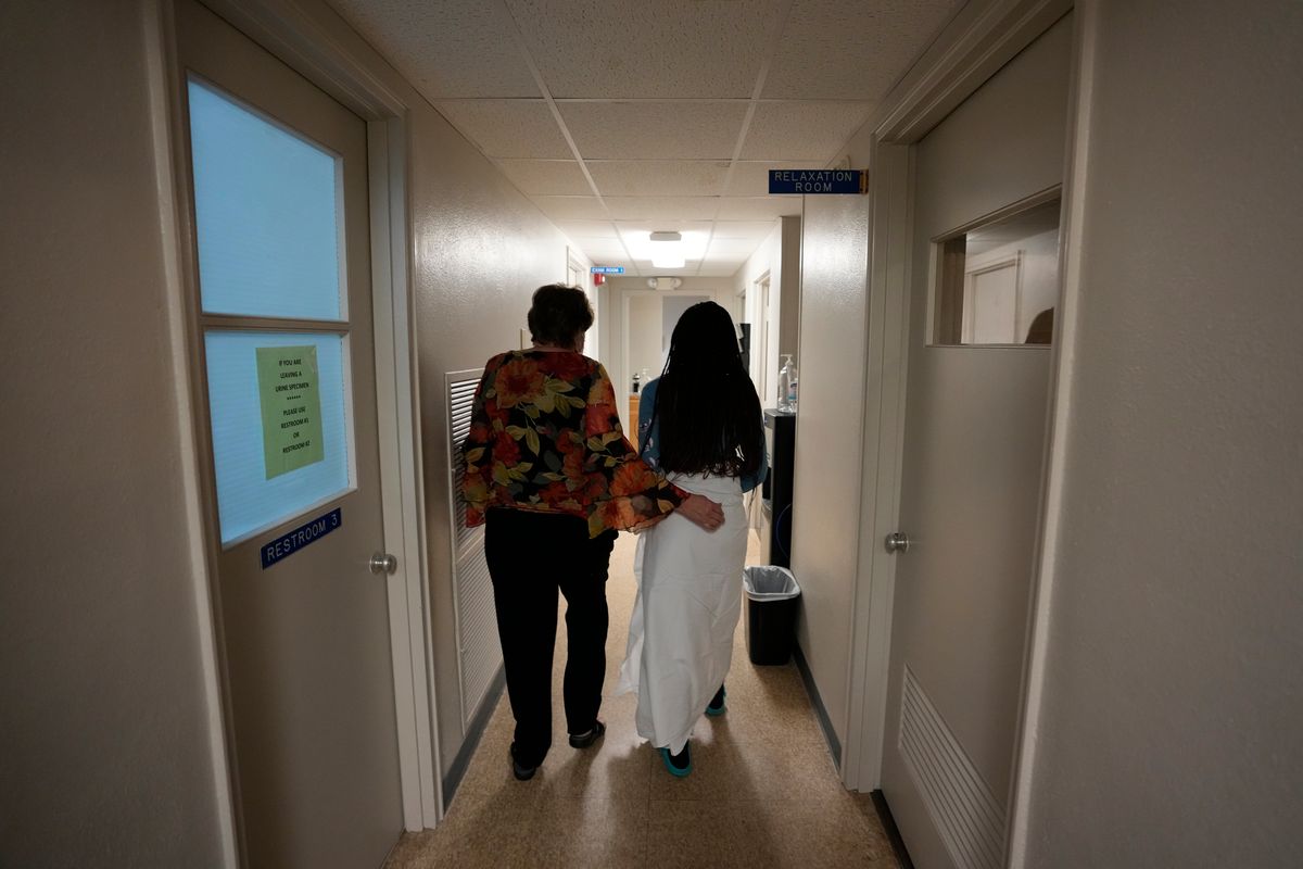 FILE - A 33-year-old mother of three from central Texas is escorted down the hall by clinic administrator Kathaleen Pittman prior to getting an abortion, Oct. 9, 2021, at Hope Medical Group for Women in Shreveport, La. Reproductive rights advocates are planning to open new abortion clinics or expand the capacity of existing ones in states without restrictive abortion laws.  (Rebecca Blackwell)