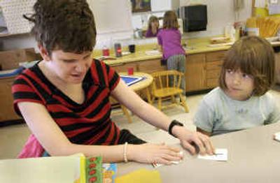 
Verina Chappell, a Lake City High School senior who is blind and has other disabilities, uses Braille flashcards with kindergartner Summer Muse at Borah Elementary School on Wednesday. Kindergarten teacher Barb Sinsley, who taught Chappell as a kindergartner, lets Chappell come to class to tutor and read to her students. 
 (Jesse Tinsley photos/ / The Spokesman-Review)