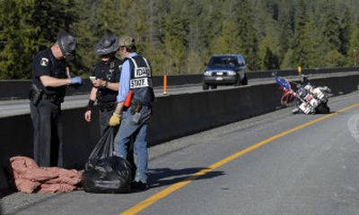 
  Idaho State Police Trooper Chuck Robnett, left, helps another trooper and volunteer Bill 