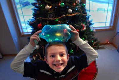 
Carson Valley, 6, proudly displays his empty piggy bank after he donated its contents to the Christmas Fund on Saturday. 
 (Brian Plonka / The Spokesman-Review)