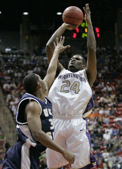 
Washington's Jamaal Williams shoots over Utah State's Chaz Spicer during Thursday's first half. 
 (Associated Press / The Spokesman-Review)