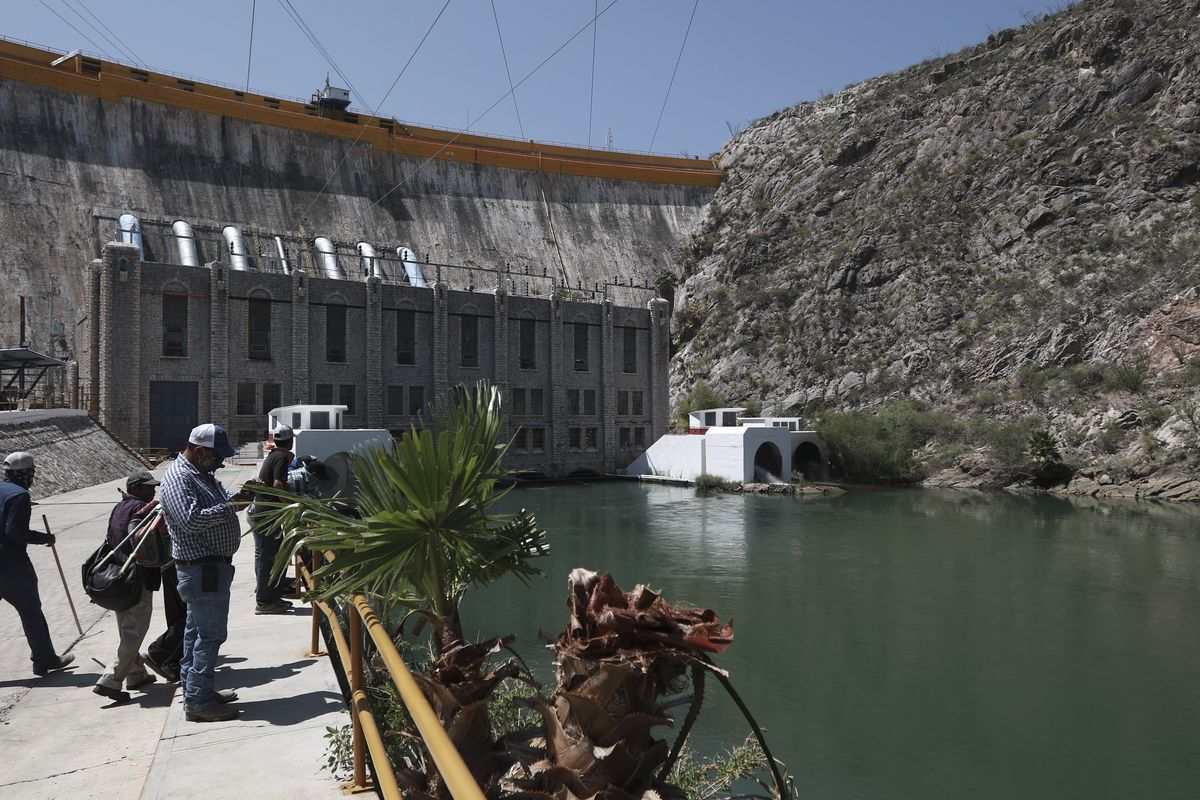 Farmers stand at La Boquilla Dam, where they wrested control on Tuesday from National Guard troops in order to close the valves and reduce the flow of water toward the United States, in Chihuahua State, Wednesday, Sept. 9, 2020. Tuesday