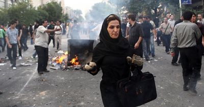 In this photograph posted on the internet, an Iranian woman carries rocks at an anti-government protest in Tehran, Iran, on Saturday.  (Associated Press / The Spokesman-Review)