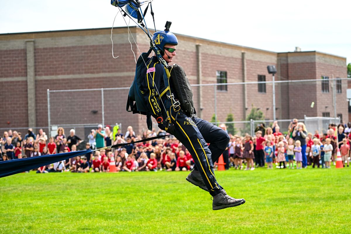 U.S. Navy Leap Frog member Lt. Nick Obletz touches down on the grounds of St. Aloysius Catholic School during a parachute demonstration Wednesday in Spokane. Obletz has made over 700 jumps.  (DAN PELLE/THE SPOKESMAN-REVIEW)