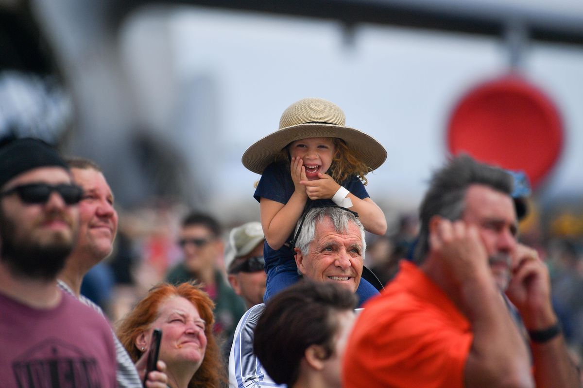 Charolette Erwin reacts to the sound of a passing F-22 Raptor as she sits on her grandfather Bill Oswalt