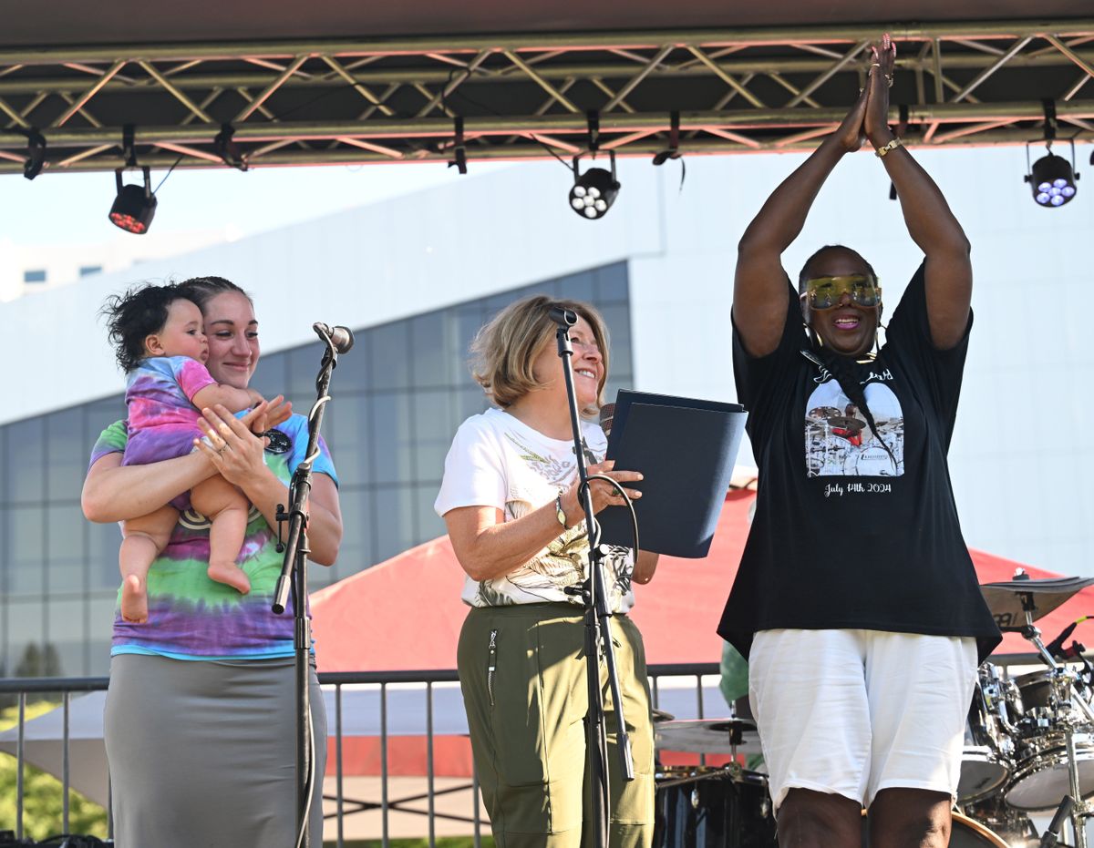 Erica Davis, right, mother of the late Quindrey Davis, claps after Spokane Mayor Lisa Brown, center, proclaims July 14 as "Drey Day," a tribute to the late Quindrey Davis, a beloved local musician and music teacher, before a concert in Riverfront Park. At left is Allison Davis, Drey