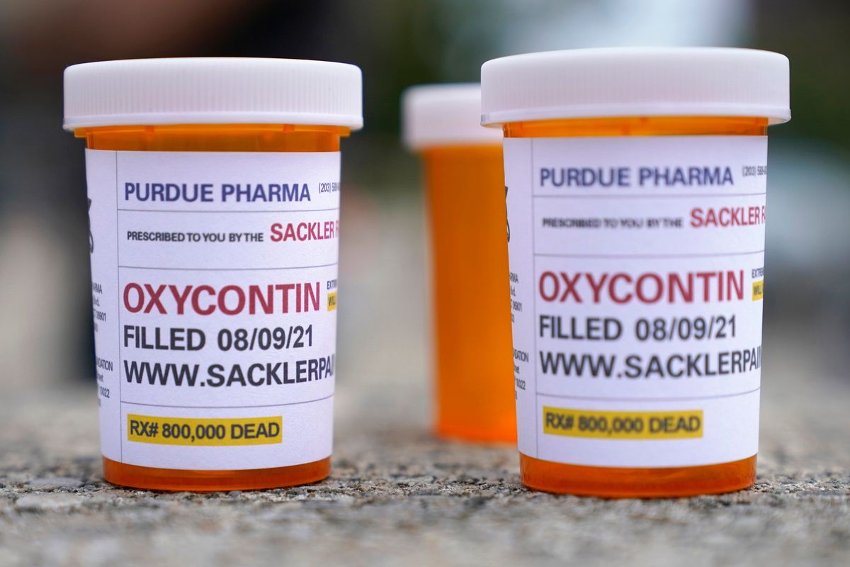 In this Aug. 9, 2021, file photo, fake pill bottles with messages about OxyContin maker Purdue Pharma are displayed during a protest outside the courthouse where the bankruptcy of the company is taking place in White Plains, N.Y.    (Seth Wenig)