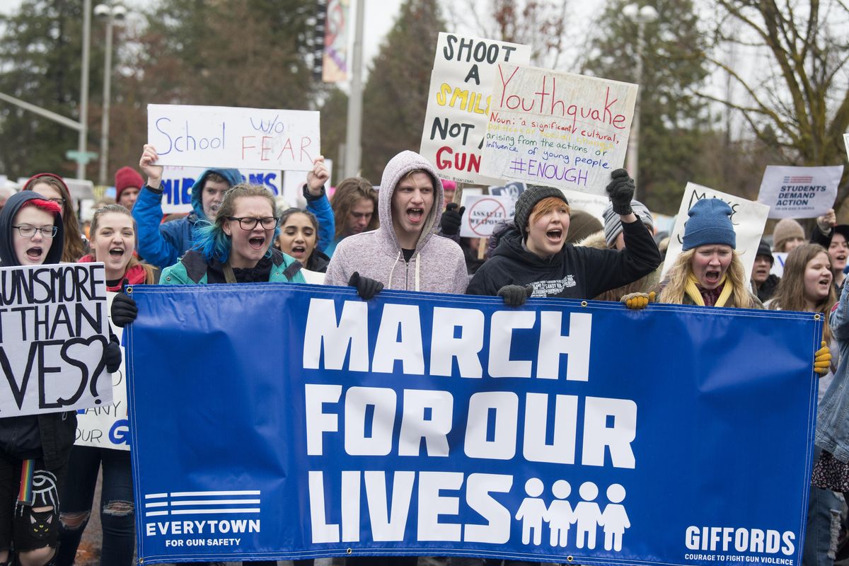 At the front of the column of protesters, young people chant slogans and carry signs through downtown Spokane, Saturday, Mar. 24, 2018. The March For Our Lives protests took place across the United States, with marches often led by high school aged youth. (Jesse Tinsley / The Spokesman-Review)