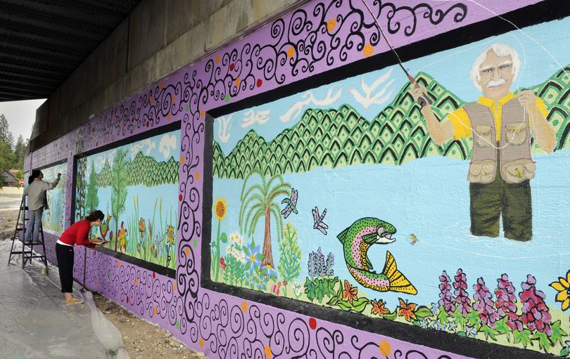 Melissa Cole, 43, and Sarah Pierce, 18, add a few final touches of detail to the railway underpass at Fourth Avenue and Sunset Boulevard on July 1. The theme for this mural is “The Wacky World of Harold Balazs.”  (Dan Pelle)