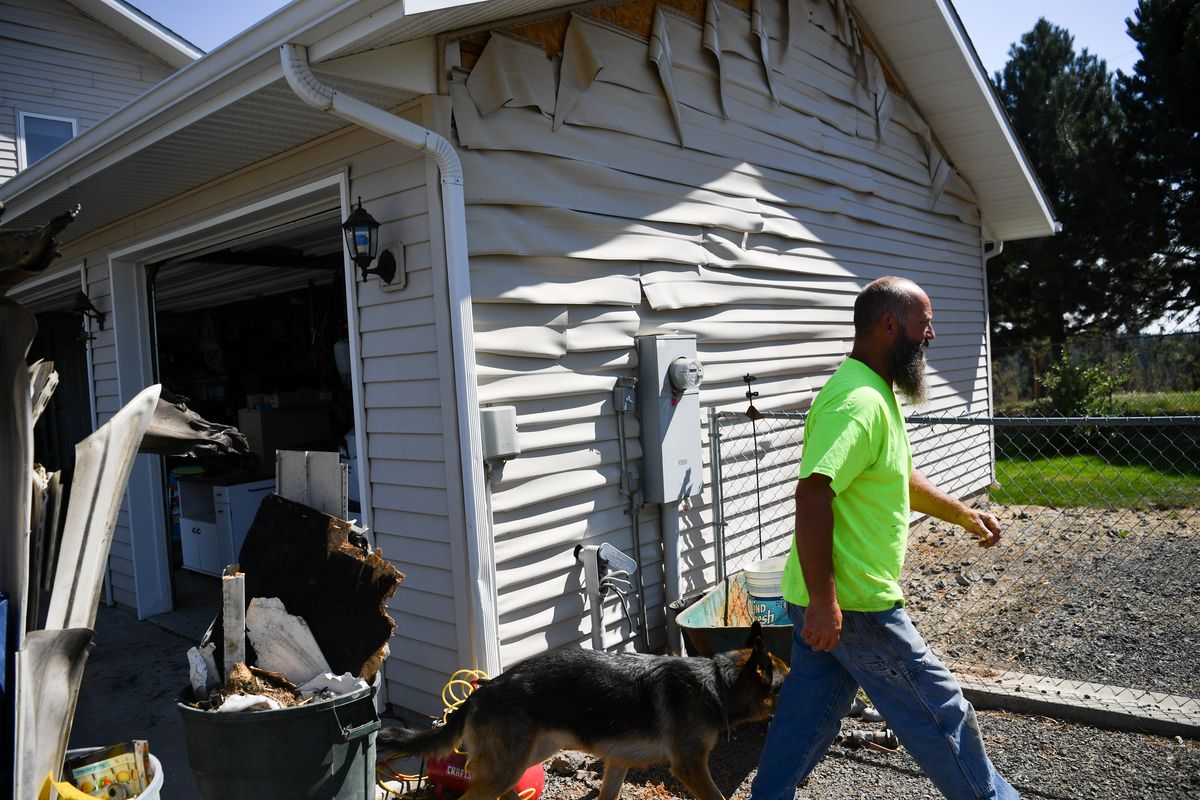 Peter Christianson on Wednesday shows the ripples in his home’s siding where flames from the Badger Lake fire nearly destroyed the house Sunday evening outside Cheney.  (Tyler Tjomsland/THE SPOKESMAN-RE)