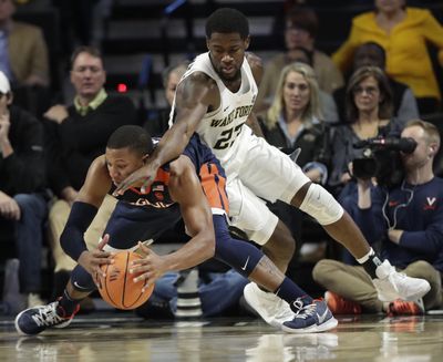 Virginia's Devon Hall, left, tries to save the ball as Wake Forest's Chaundee Brown defends during the second half of an NCAA basketball game in Winston-Salem, N.C., Sunday, Jan. 21, 2018. (Chuck Burton / Associated Press)