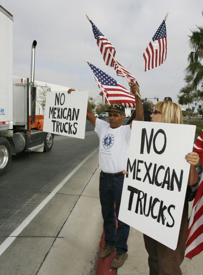 Protesters hold signs as a truck entering the U.S. from Mexico leaves the California Highway Patrol Otay Mesa Inspection Station in San Diego. Washington state agricultural interests could lose millions of dollars of business in a dispute over allowing Mexican trucks onto U.S. highways. (File Associated Press / The Spokesman-Review)
