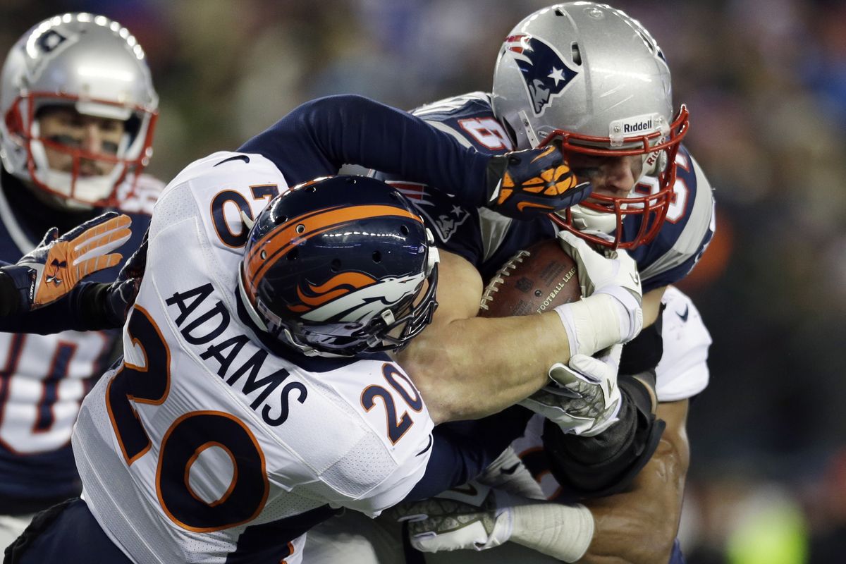 Broncos safety Mike Adams wraps up New England Patriots tight end Rob Gronkowski in the third quarter of Sunday night’s game. (Associated Press)