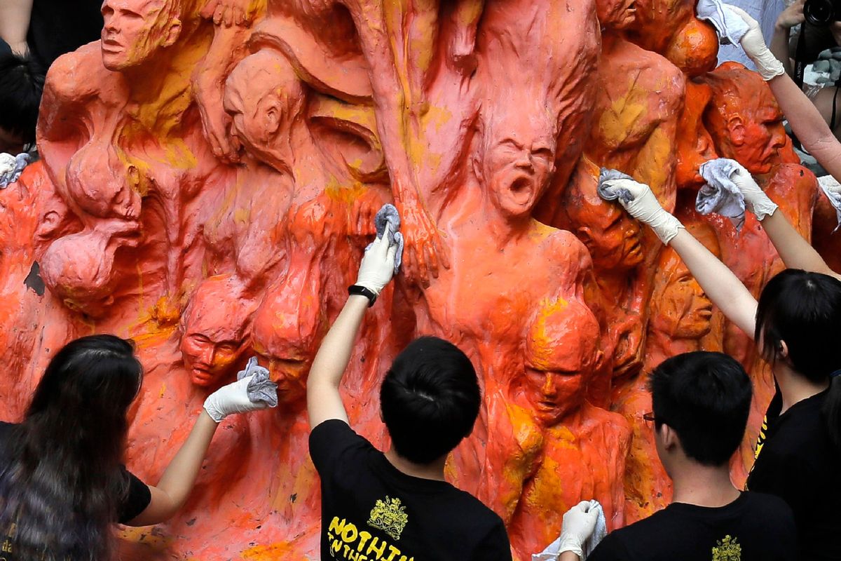University students clean the “Pillar of Shame” statue, a memorial for those killed in the 1989 Tiananmen crackdown, at the University of Hong Kong, on June 4, 2019. (Kin Cheung)
