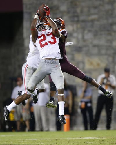 Ohio State safety Tyvis Powell, front, intercepts a pass intended for Virginia Tech wide receiver Isaiah Ford during the second half. (Associated Press)