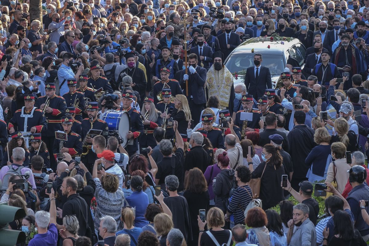People gather to pay their last respect to the late Greek composer Mikis Theodorakis, as the hearse drives among the crowd, prior to his burial, in Chania, Crete island, Greece, Thursday, Sept. 9 2021. Theodorakis died Thursday, Sept. 2, 2021 at 96. He penned a wide range of work, from somber symphonies to popular TV and film scores, including for “Serpico” and “Zorba the Greek.” He is also remembered for his opposition to the military junta that ruled Greece from 1967-1974, when he was persecuted and jailed and his music outlawed.    (Harry Nakos)