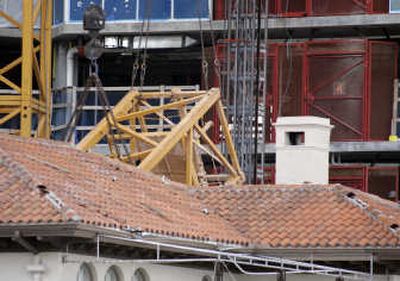 
A section of a crane, center, is lifted from a house Tuesday in Miami. Two workers were killed and five others were injured Tuesday when the crane collapsed at a high-rise condominium site. Associated Press
 (Associated Press / The Spokesman-Review)