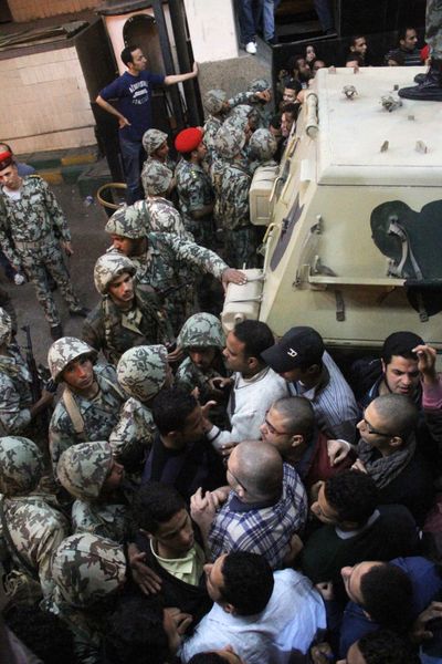Soldiers unsuccessfully try to stop protesters from storming the State Security building headquarters in Cairo’s northern Nasr City neighborhood, Egypt, Saturday. (Associated Press)