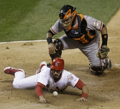 San Francisco Giants catcher Hector Sanchez can’t handle the throw as St. Louis Cardinals’ Matt Carpenter scores from second. (Associated Press)
