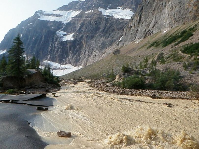 Water from Cavell Pond floods out to the Jasper National Park parking area after tons of ice from Ghost Glacier fell from the slopes of Mount Edith Cavell on Aug. 10, 2012. (Courtesy)