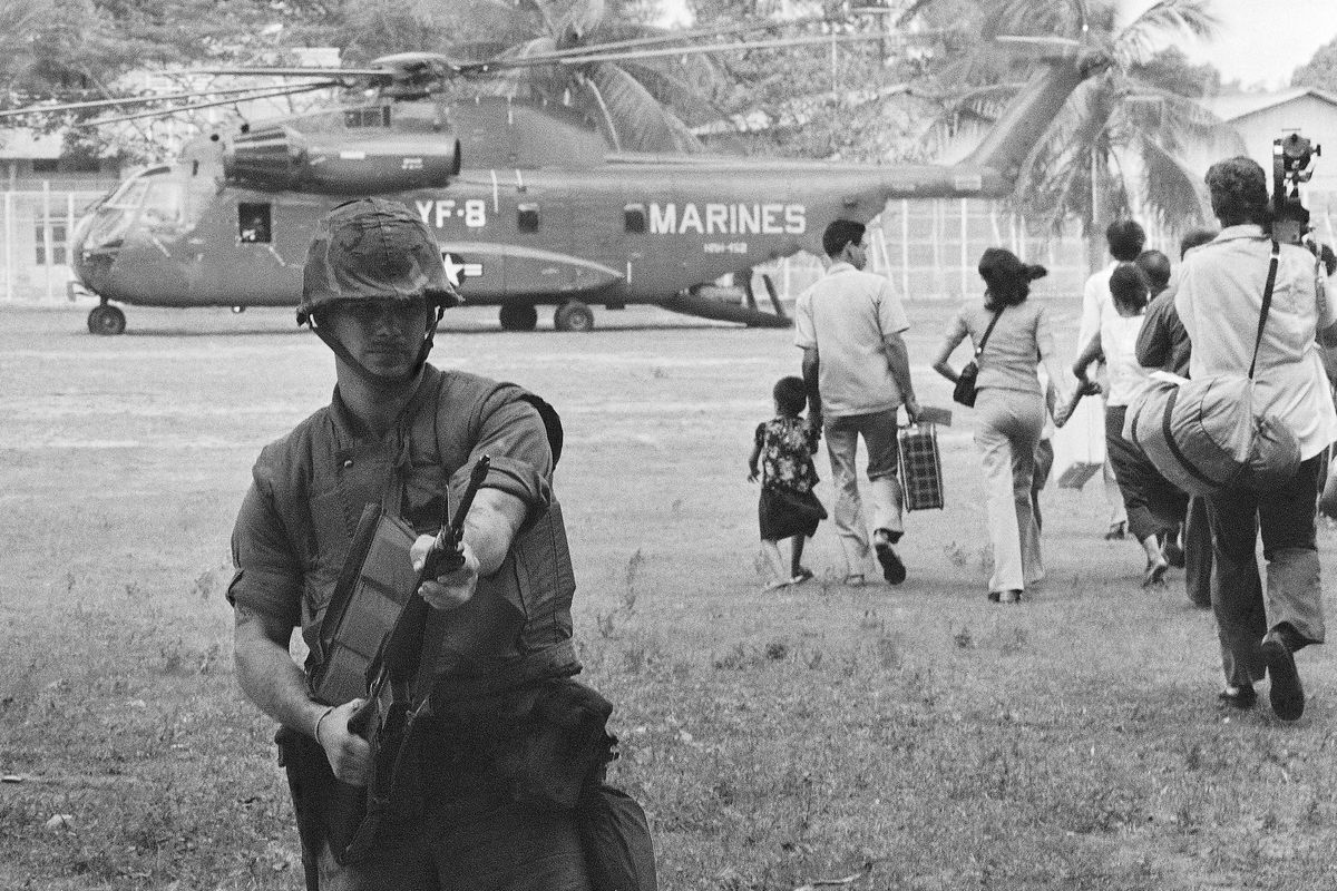 In this April 12, 1975, file photo, U.S. Marines provide cover during Operation Eagle Pull as Americans and Cambodians board Marine helicopters in Phnom Penh during the final U.S. pullout of Cambodia. Five days after Operation Eagle Pull, the dramatic evacuation of Americans, the U.S.-backed government fell as communist Khmer Rouge guerrillas stormed into Phnom Penh. Nearly 2 million Cambodians - one in every four - would die from executions, starvation and hideous torture. (Associated Press)