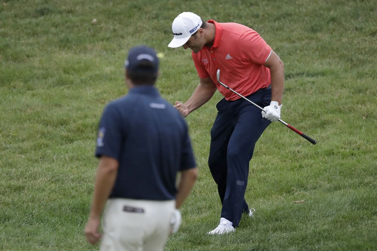Jon Rahm, of Spain, right, celebrates after chipping for birdie on the 16th hole as Ryan Palmer watches during the final round of the Memorial golf tournament, Sunday, July 19, 2020, in Dublin, Ohio.  (Darron Cummings)