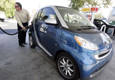 Larry Syres fills up his Smart car this summer at a Shell gas station in Palo Alto, Calif. Syres says  he averages 42 miles per gallon.  (File Associated Press / The Spokesman-Review)