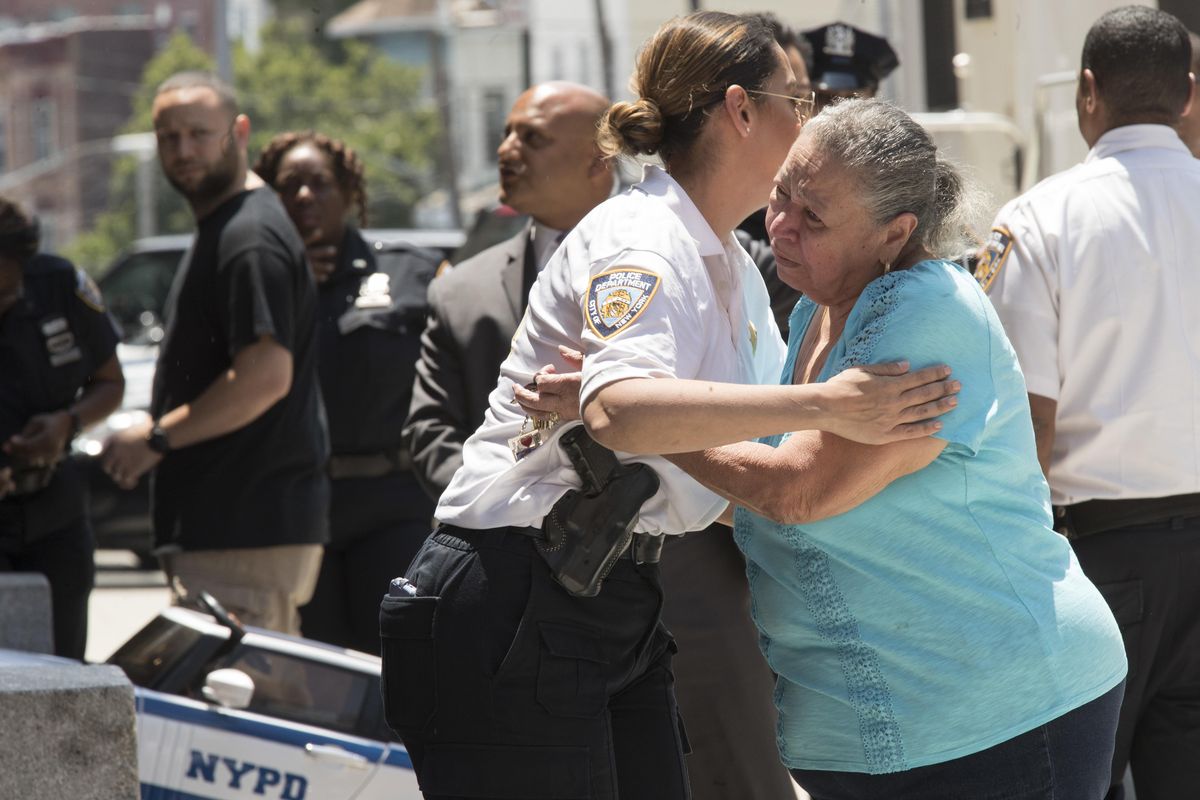 Neighborhood resident Maria Santiago, 77, is consoled by a police officer as she pays her respects outside the 46th Precinct in the Bronx borough of New York, Wednesday, July 5, 2017. A police officer from the 46th Precinct was shot to death early Wednesday, ambushed inside her command post RV by an ex-convict who once ranted online about his treatment in prison and about police getting away with killing people, authorities said. He was later killed after pulling a gun on police. (Mary Altaffer / AP)