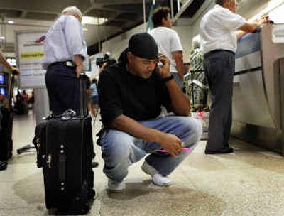 
Joshua Edwards talks on a cellular phone to Southwest Airlines representatives in the check-in area for Southwest at Lindbergh Field in San Diego while trying to figure out a way to get back to Sacramento, Calif., on Tuesday night. 
 (Associated Press / The Spokesman-Review)