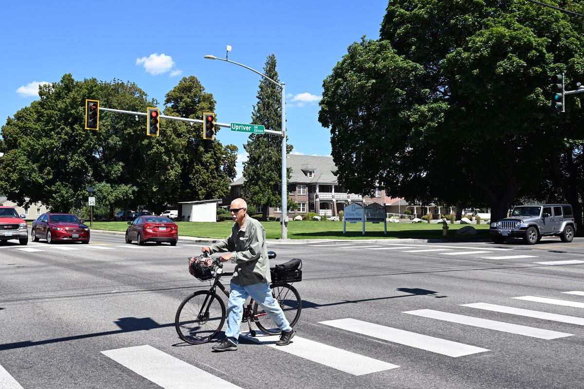 A cyclist on the Centennial Trail in the Millwood area uses the crosswalk to get across North Argonne Road at Upriver Drive Monday, July 7, 2025, just one obstacle to using the Centennial Trail in between Boulder Beach and Farr Road, where the trail is reduced to a narrow path on the shoulder of Upriver Drive. The Friends of the Centennial Trail is hoping the state would share funding to make the trail safer, perhaps adding an overpass or underpass to allow trail users to cross Argonne safely. . (Jesse Tinsley/THE SPOKESMAN-REVIEW)