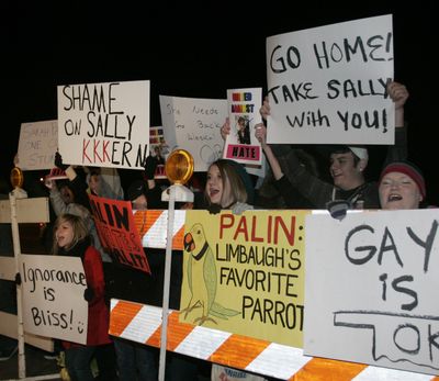 Protestors wave signs outside a barricade at a local bookstore in Norman, Okla., where former Alaska Gov. Sarah Palin is signing copies of her book, 