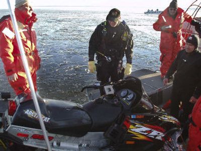 
Officials look over Paul Blanco's snowmobile,  which they retrieved from Sebago Lake, Maine, on Tuesday.  Blanco is  missing and  presumed dead after an accident over the weekend. 
 (Associated Press / The Spokesman-Review)