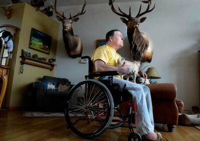 Thomas Grieb sits in his Eagle Ridge subdivision home with his pug dog on Feb. 18.  (Christopher Anderson / The Spokesman-Review)